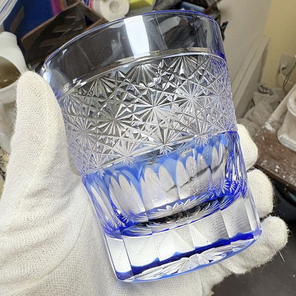 平透かし菊繋ぎ天開ロックグラス・青の手に持った時の正面から見た時の写真。